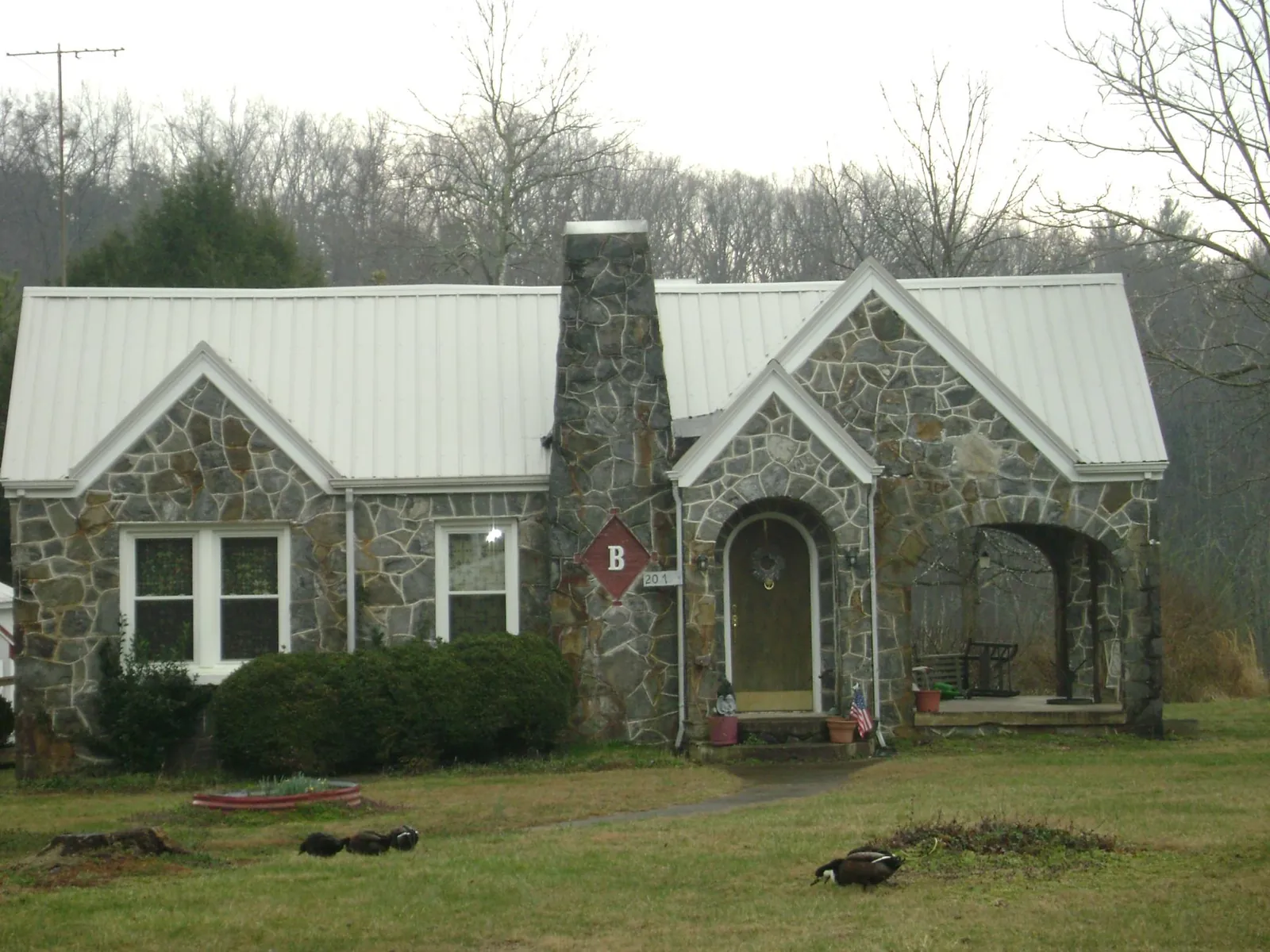 White metal roof on a stone cottage with steep gables in Bird In Hand